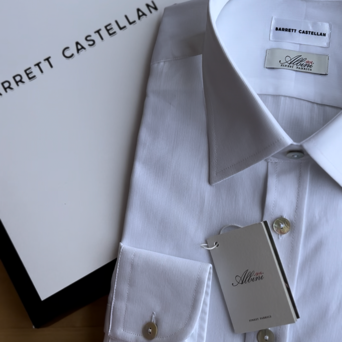 White dress shirt with Barrett Castellan tag on a wooden surface